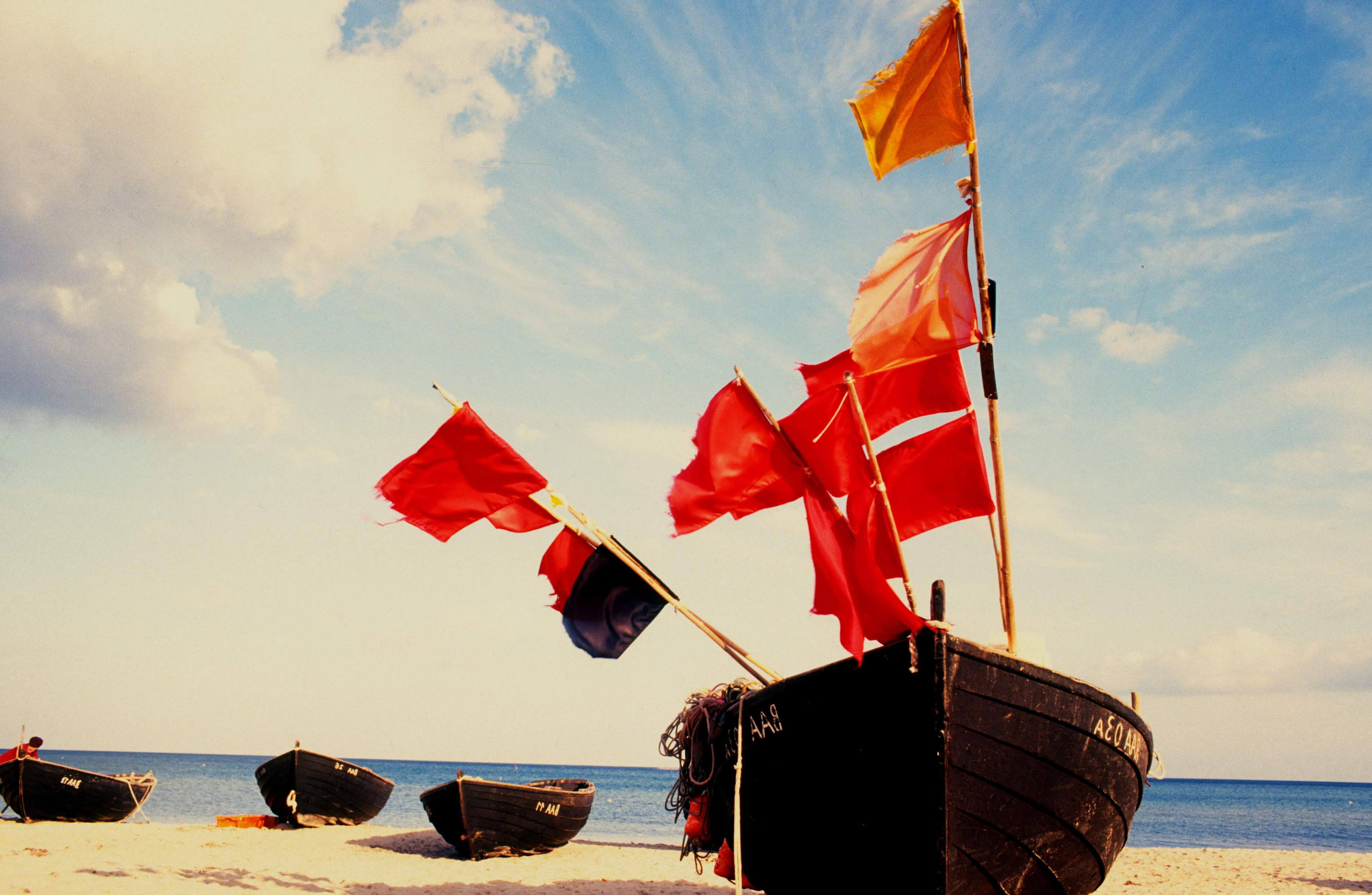 row boat with red flags on stranded island