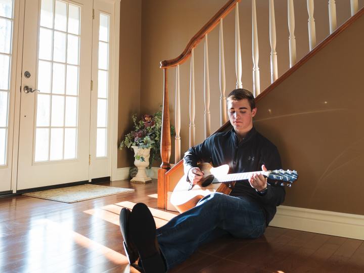 Man playing guitar alone at home